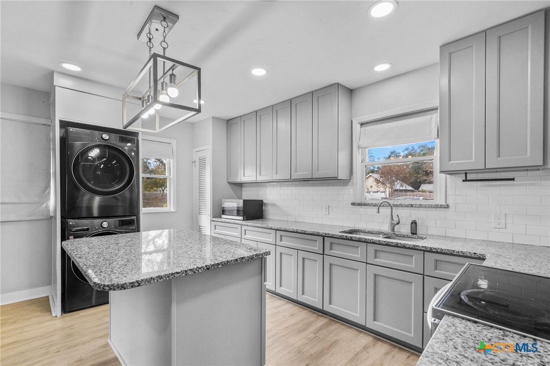 3109 North Main Street Victoria, TX 77901 - Photo 7 of 29 a kitchen with granite countertop a sink a stove and cabinets