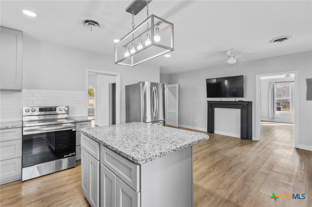 3109 North Main Street Victoria, TX 77901 - Photo 8 of 29 a kitchen with kitchen island a sink stainless steel appliances and wooden floor
