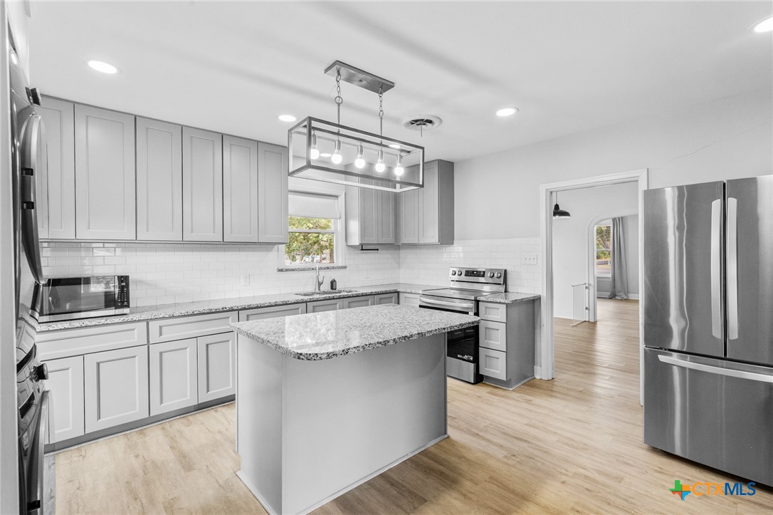 3109 North Main Street Victoria, TX 77901 - Photo 10 of 29 a kitchen with stainless steel appliances granite countertop a sink stove and refrigerator