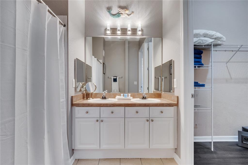 505 Terrace Ridge Circle, Unit 505 Davenport, FL 33896 - Photo 14 of 47 a bathroom with a double vanity sink and a mirror