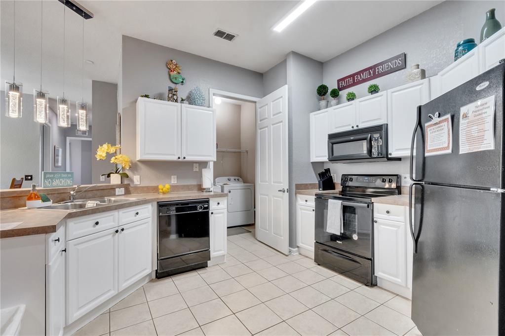 505 Terrace Ridge Circle, Unit 505 Davenport, FL 33896 - Photo 2 of 47 a kitchen with cabinets stainless steel appliances and a counter top space