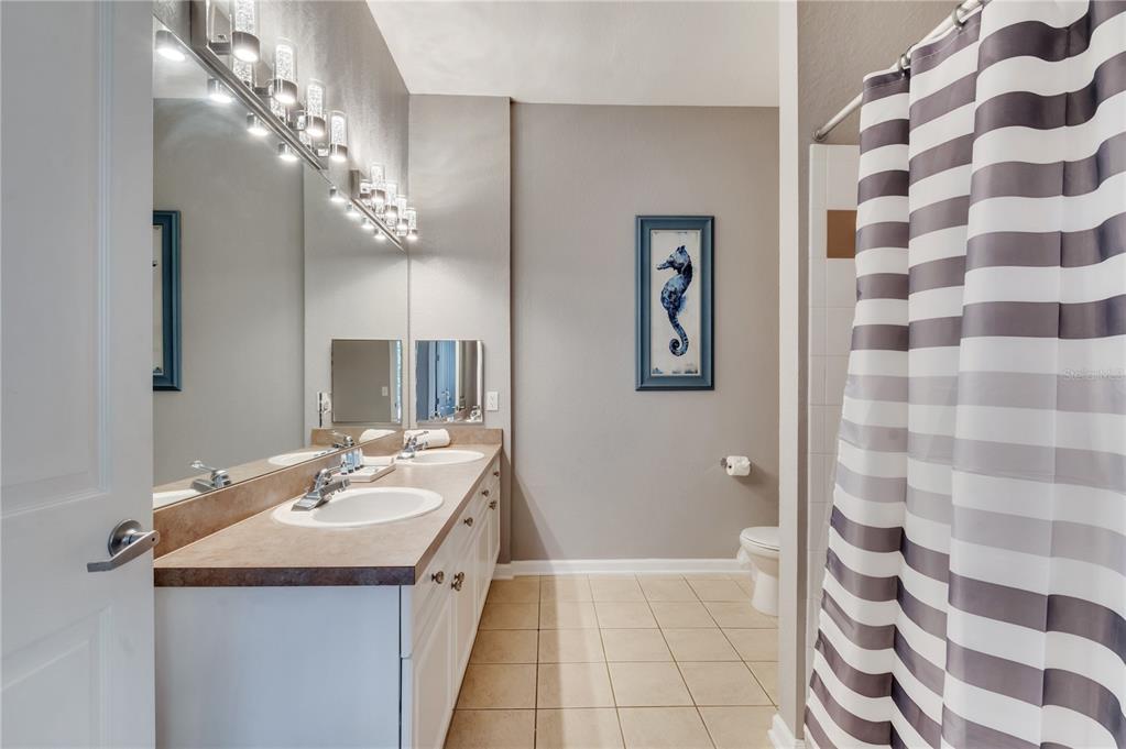 505 Terrace Ridge Circle, Unit 505 Davenport, FL 33896 - Photo 27 of 47 a bathroom with a sink a large mirror and a shower
