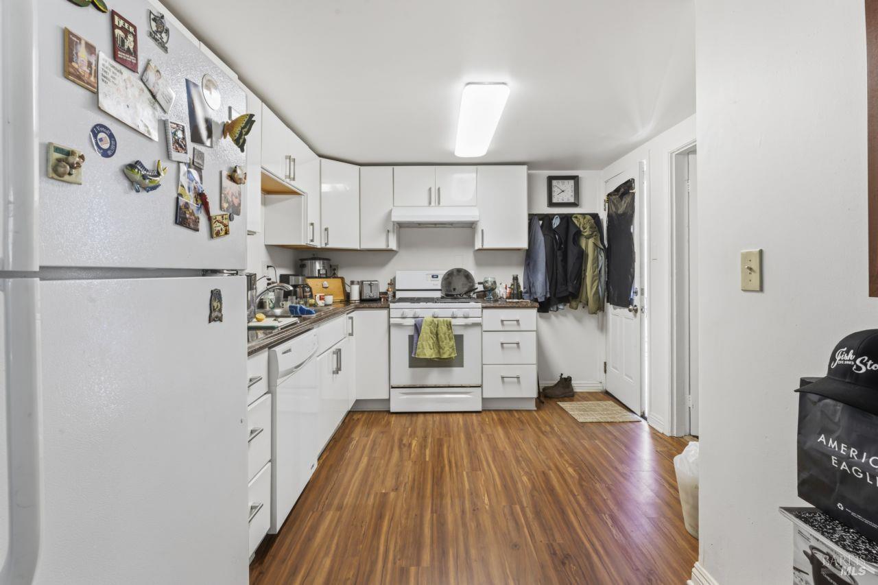 111 Altena Street San Rafael, CA 94901 - Photo 18 of 46 a kitchen with cabinets a refrigerator and a stove with wooden floor