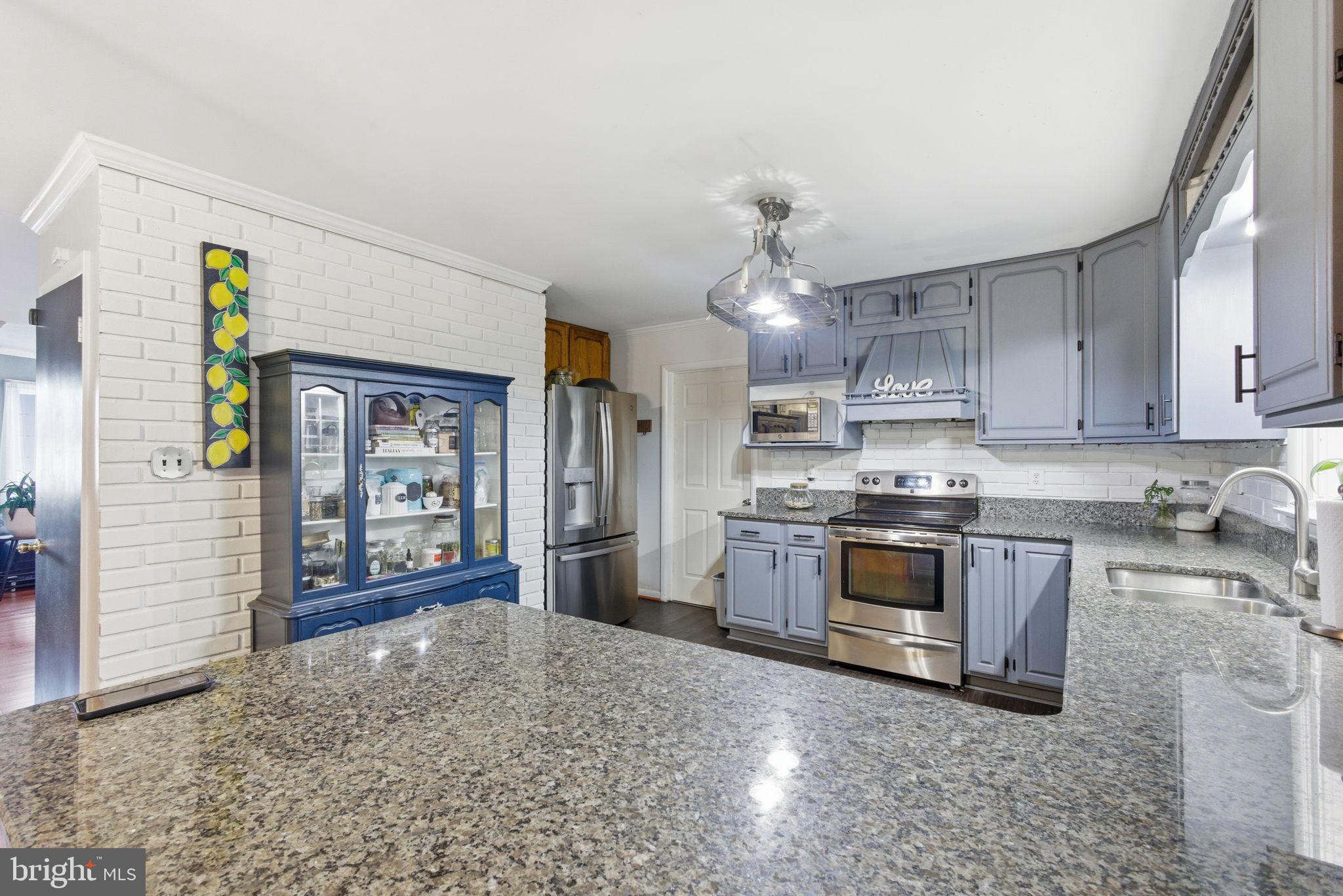 9769 Trinity Church Road Charlotte Hall, MD 20622 - Photo 7 of 61 a kitchen with stainless steel appliances granite countertop a stove sink and cabinets