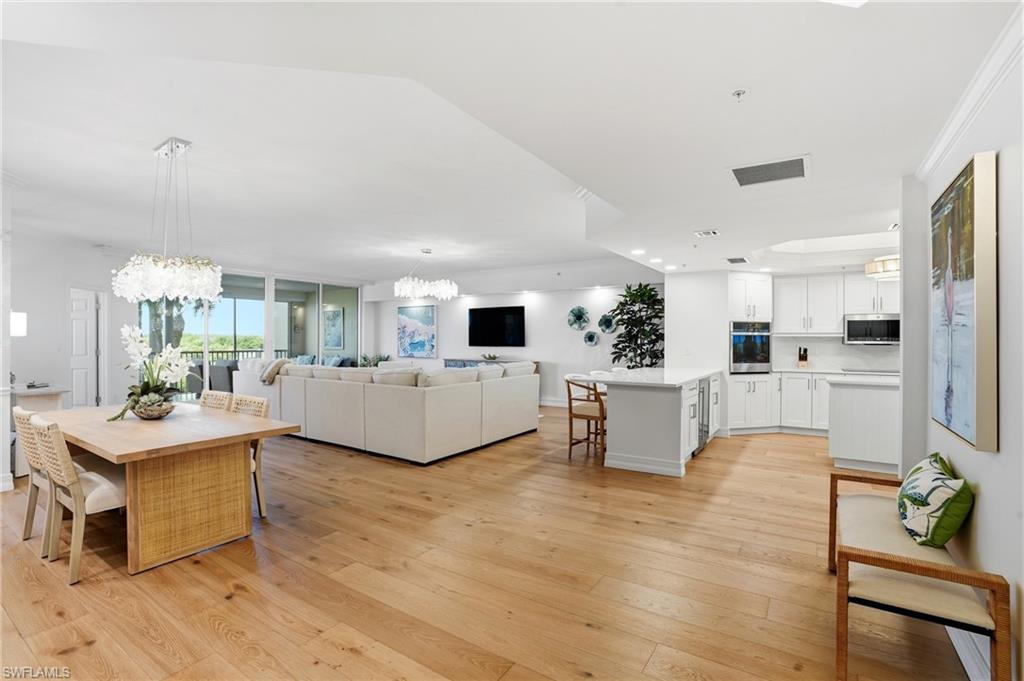 445 Dockside Drive, Unit B202 Naples, FL 34110 - Photo 2 of 50 a living room with furniture a flat screen tv and kitchen view