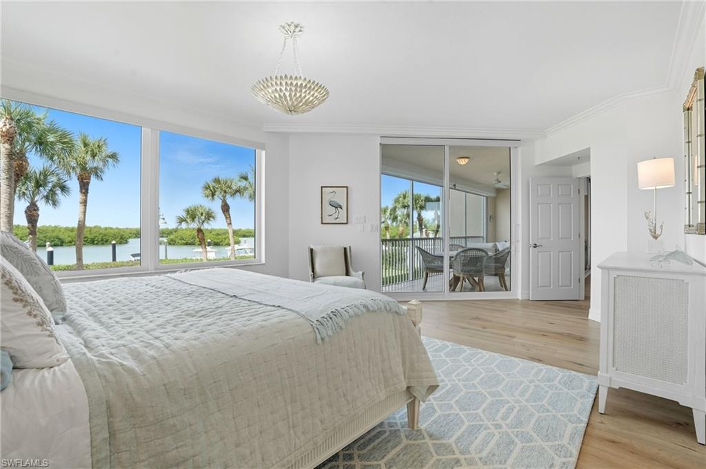 445 Dockside Drive, Unit B202 Naples, FL 34110 - Photo 23 of 50 a bedroom with a bed and a chandelier