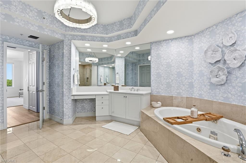 445 Dockside Drive, Unit B202 Naples, FL 34110 - Photo 25 of 50 The Master Bathroom boasts a Stunning Chandelier and Jacuzzi Tub.