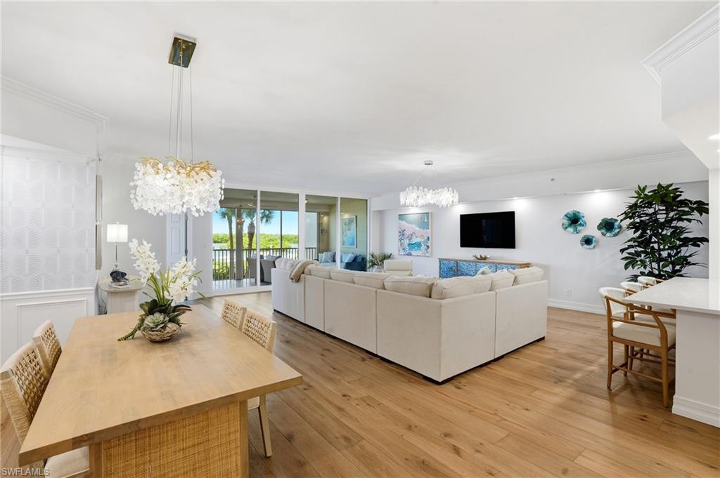 445 Dockside Drive, Unit B202 Naples, FL 34110 - Photo 3 of 50 a living room with furniture a potted plant and a flat screen tv