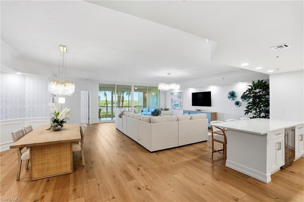 445 Dockside Drive, Unit B202 Naples, FL 34110 - Photo 8 of 50 a living room with furniture a flat screen tv and a large window