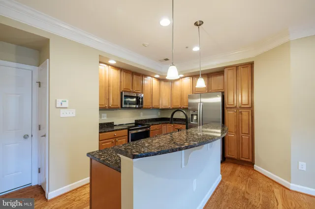 a kitchen with stainless steel appliances granite countertop a sink a refrigerator and a stove