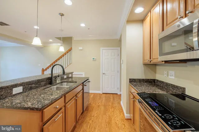 a kitchen with stainless steel appliances granite countertop a sink and a stove