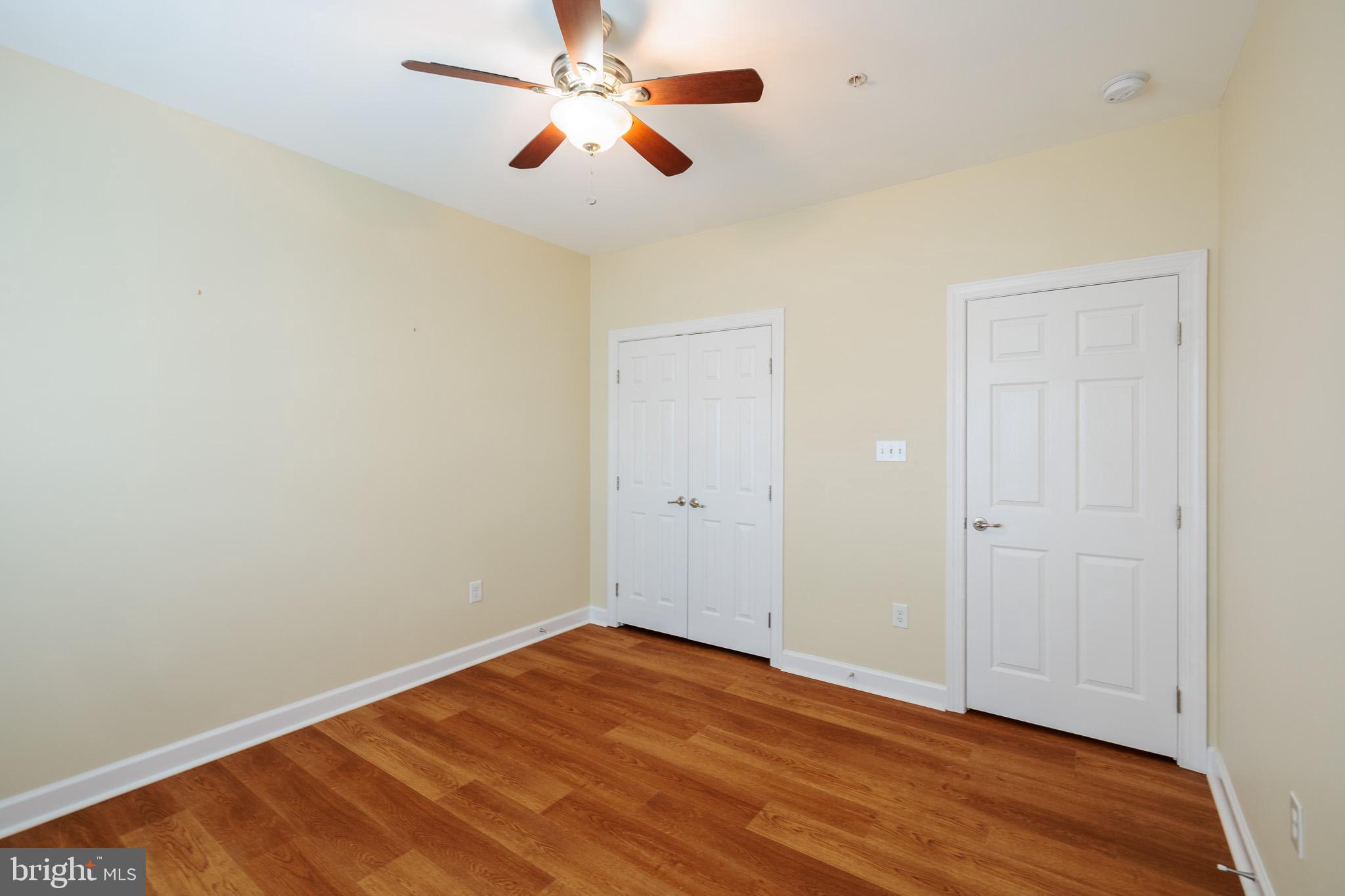 256 Urban Avenue, Unit 256 Gaithersburg, MD 20878 - Photo 34 of 41 an empty room with wooden floor ceiling fan and windows