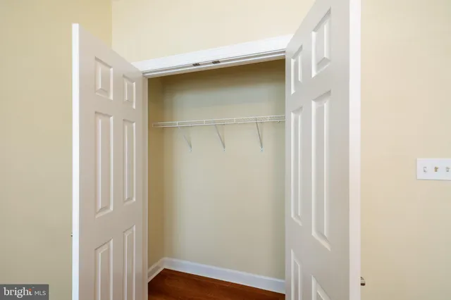an empty room with closet and fan