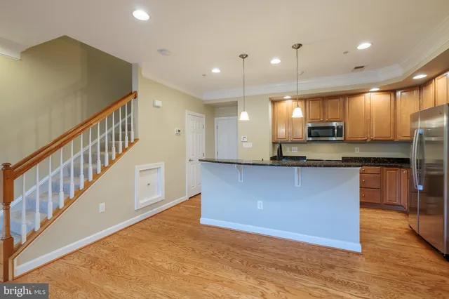 a kitchen with stainless steel appliances granite countertop a refrigerator a sink and a stove
