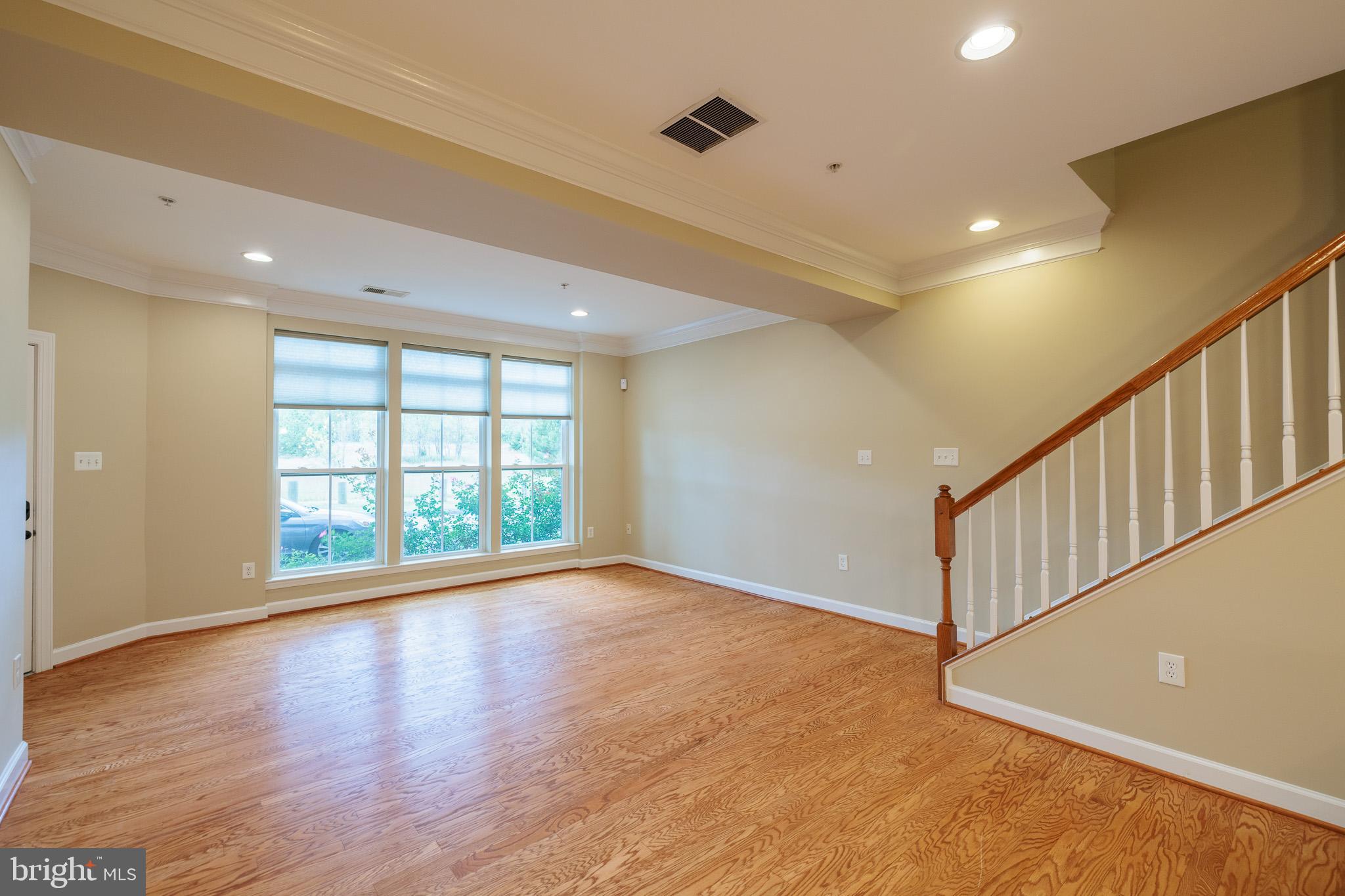256 Urban Avenue, Unit 256 Gaithersburg, MD 20878 - Photo 7 of 41 a view of an empty room with wooden floor and a window