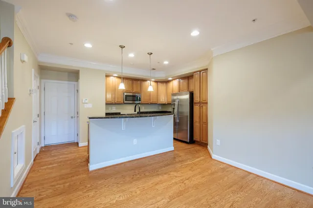 a view of kitchen and kitchen with stainless steel appliances wooden floor
