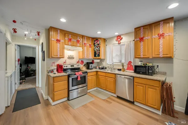a kitchen with a sink appliances cabinets and furniture