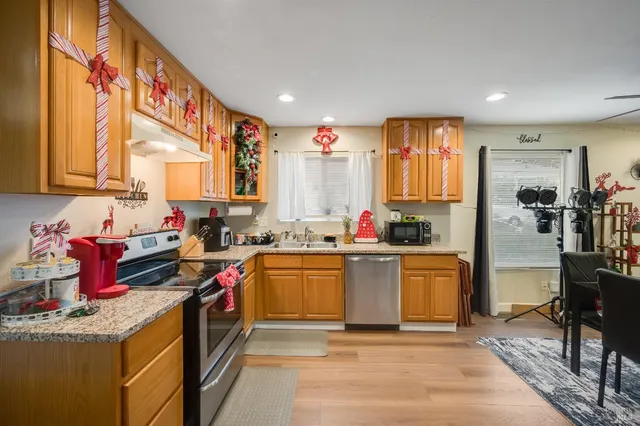 a kitchen with stainless steel appliances granite countertop a sink stove and refrigerator