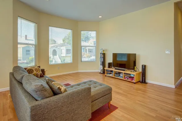 a living room with furniture a flat screen tv and a window