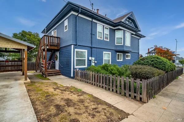 a view of a house with wooden fence