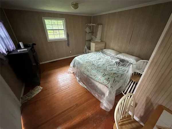 a bedroom with a bed and wooden floor