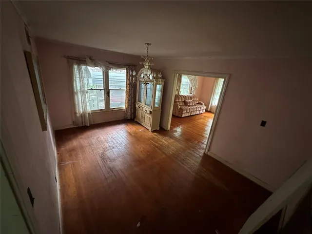 a view of a room with window wooden floor and chandelier