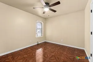 an empty room with a window and a ceiling fan