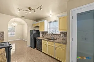 a kitchen with cabinets and window