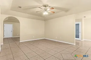 an empty room with fan and glass door
