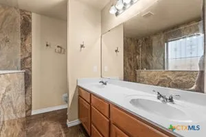 a bathroom with a double vanity sink and a mirror