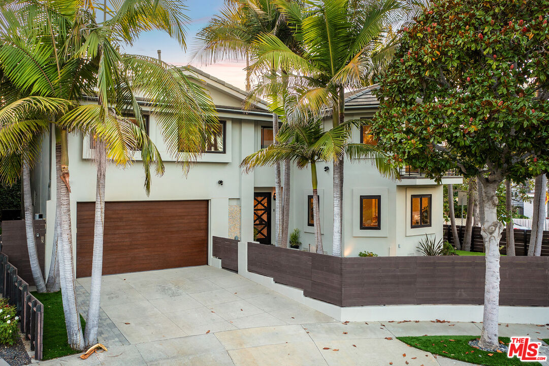 a front view of a house with a tree