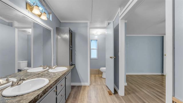 12409 Ranch Road 2341 Burnet, TX 78611 - Photo 7 of 15 a bathroom with a granite countertop sink toilet a mirror and shower