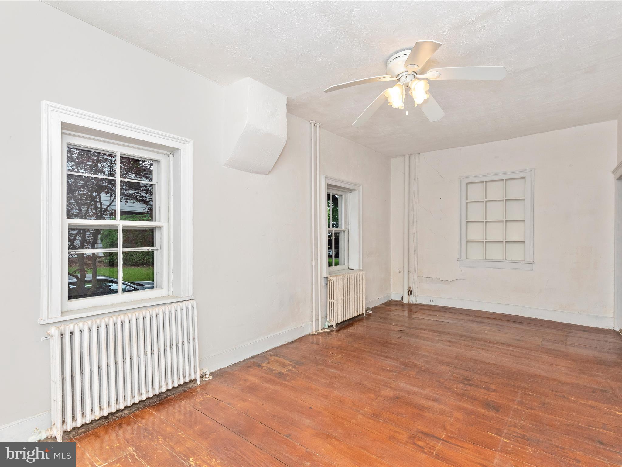3204 Uniontown Road Westminster, MD 21158 - Photo 35 of 51 an empty room with wooden floor fan and windows