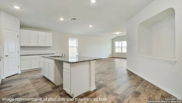 a kitchen with white cabinets and sink