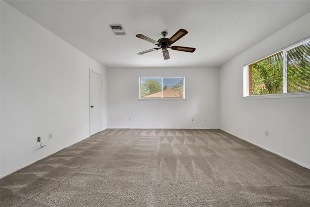 a view of a livingroom with a ceiling fan and window