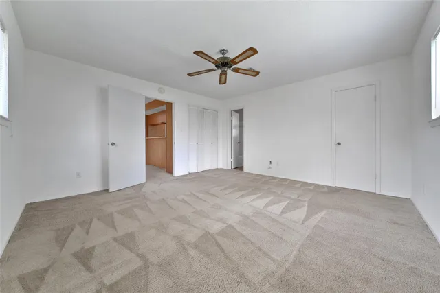 a view of a livingroom with a ceiling fan and window