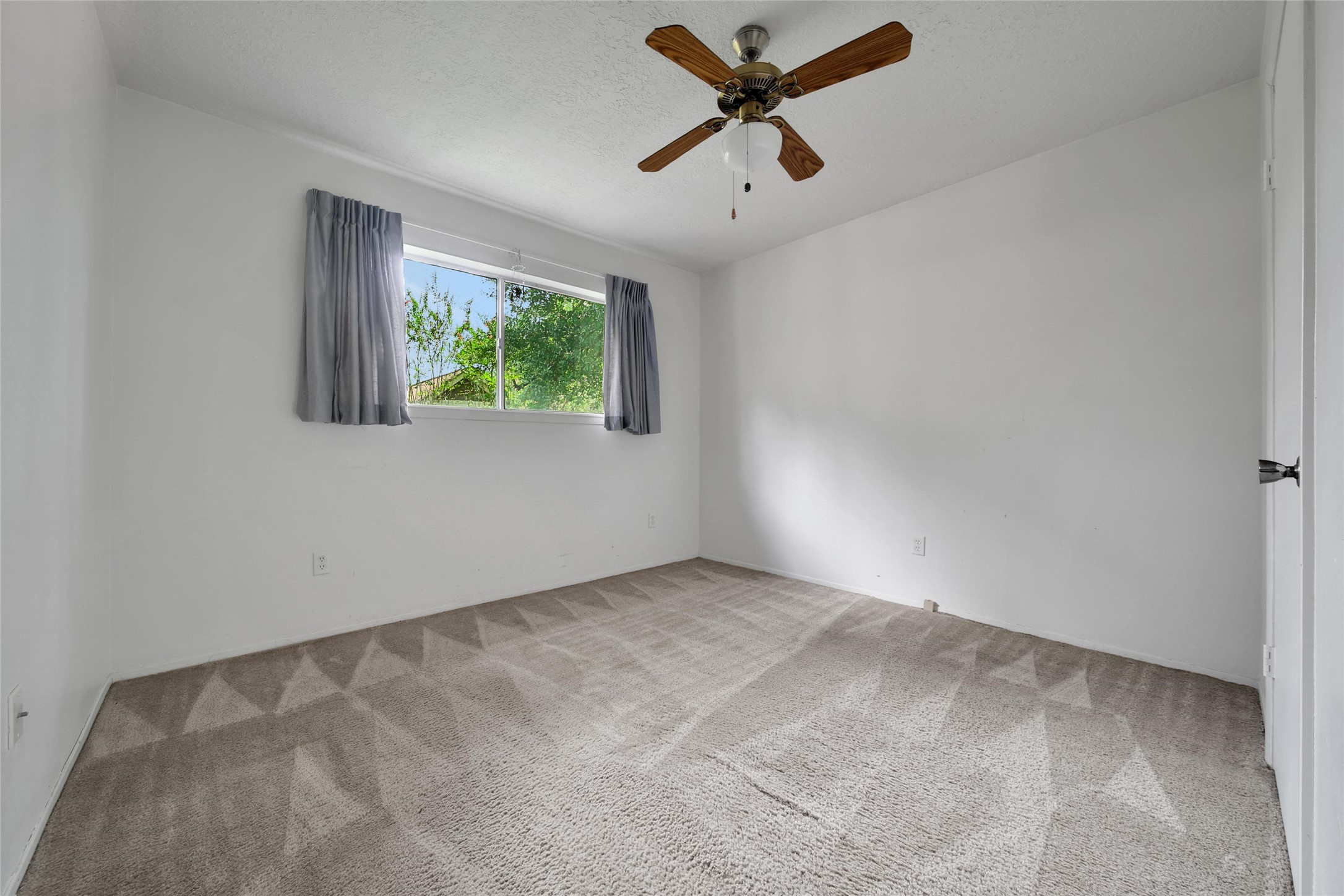 1712 Lindy Lane Conroe, TX 77301 - Photo 17 of 20 an empty room with a window and a fan