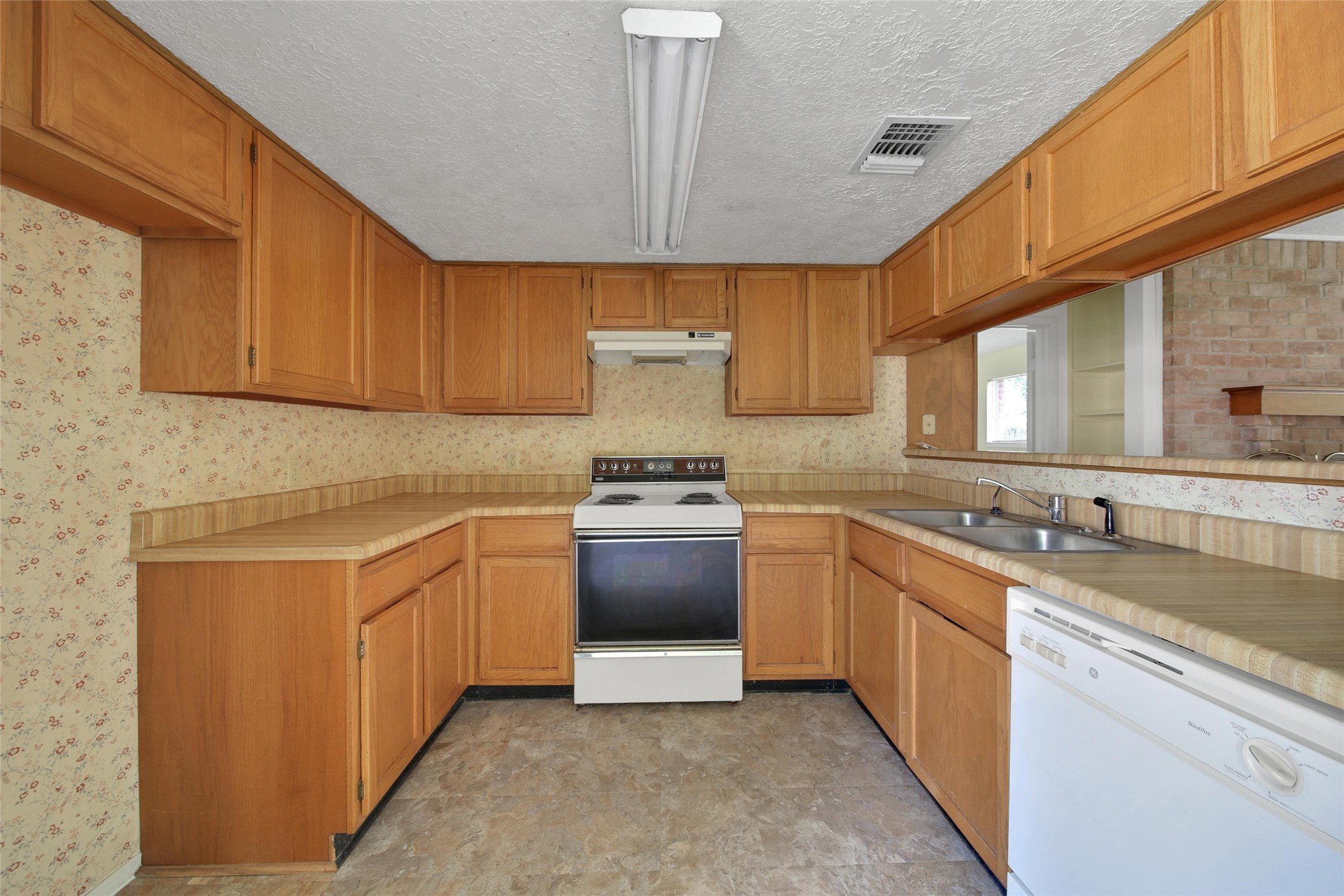 1712 Lindy Lane Conroe, TX 77301 - Photo 10 of 20 a kitchen with stainless steel appliances granite countertop a sink stove and refrigerator