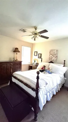 a spacious bedroom with a bed and a chandelier