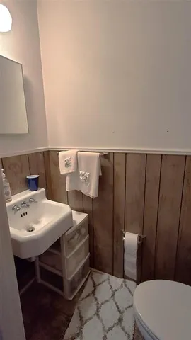 a bathroom with a sink a toilet and mirror