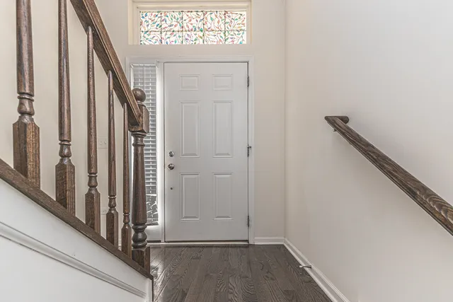 a view of a hallway with wooden floor and a chandelier
