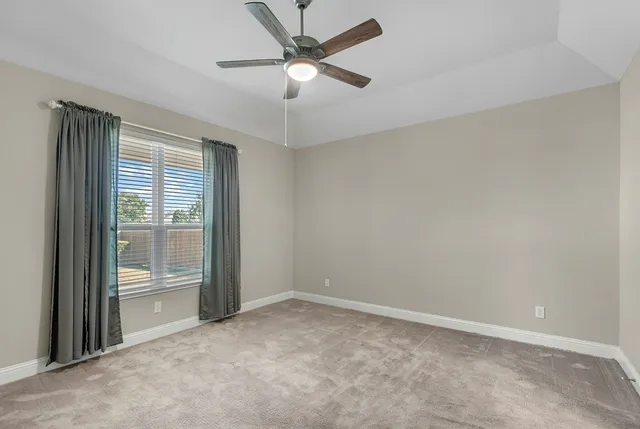an empty room with fan and windows