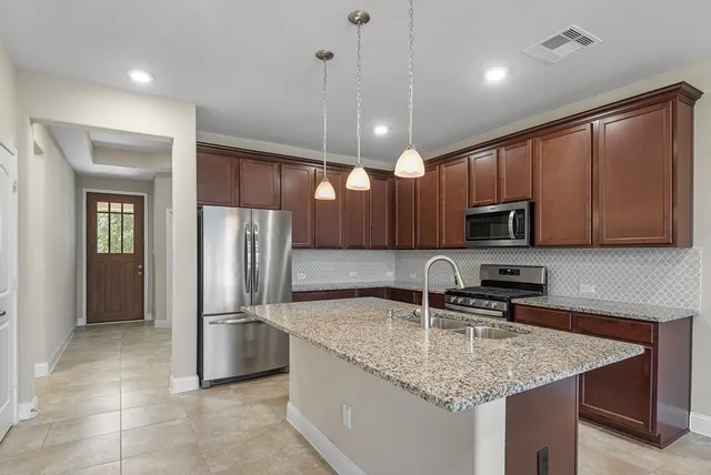 a kitchen with stainless steel appliances granite countertop a sink refrigerator and microwave