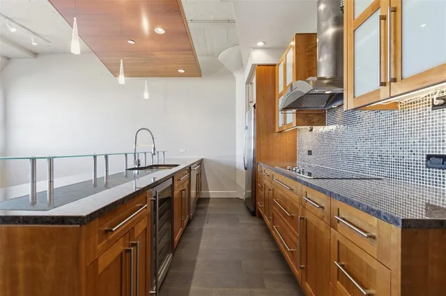 a kitchen with kitchen island stainless steel appliances a sink stove and cabinets
