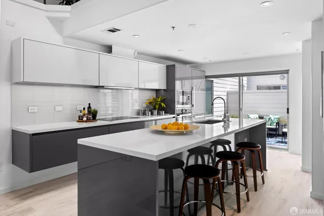 a kitchen with stainless steel appliances a sink a stove and white cabinets