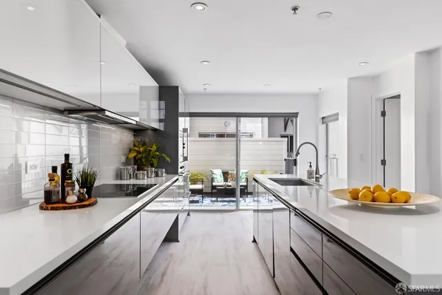 a kitchen with a sink a stove and white cabinets