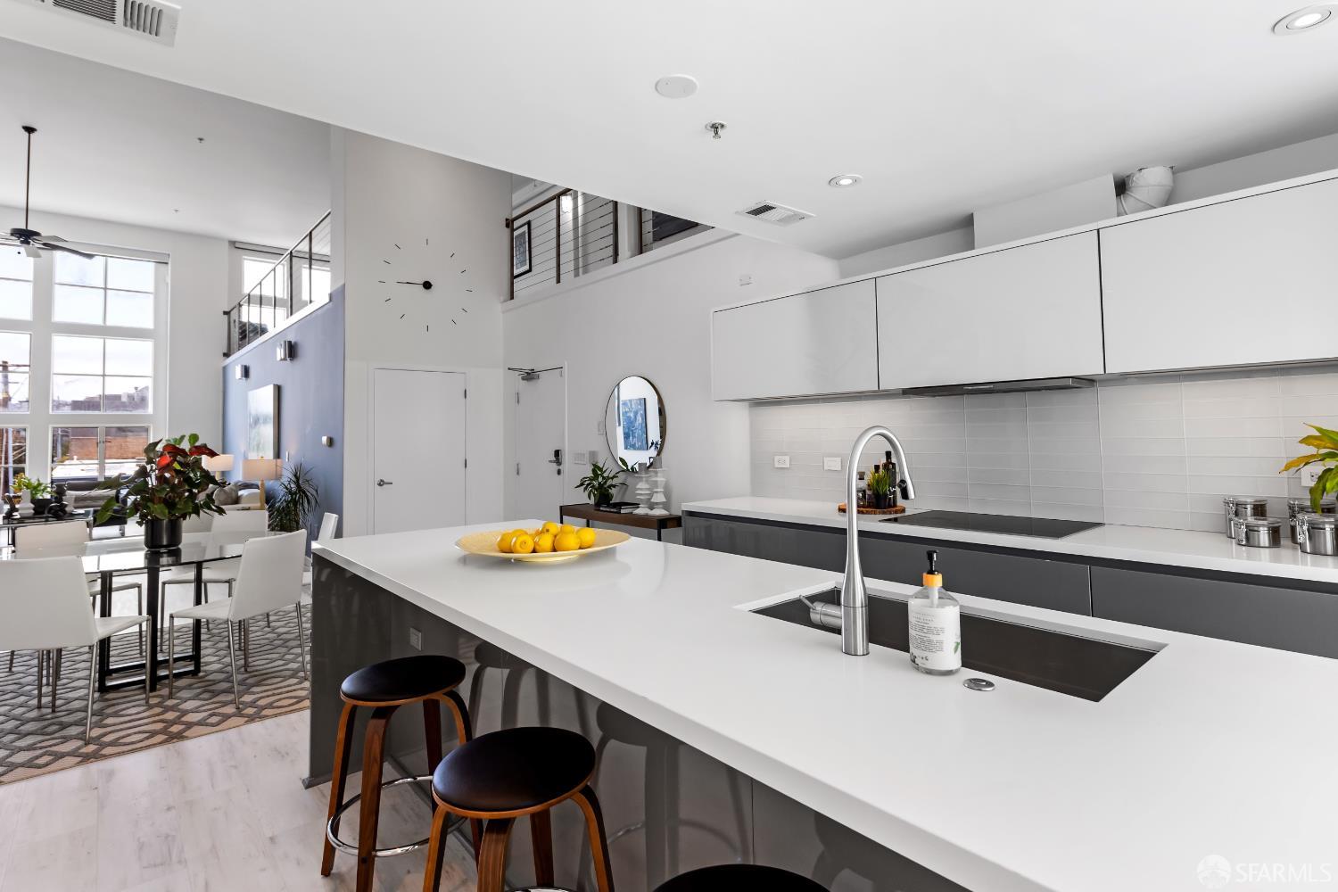 229 8th Street, Unit 3 San Francisco, CA 94103 - Photo 21 of 61 a kitchen with a sink a stove and white cabinets