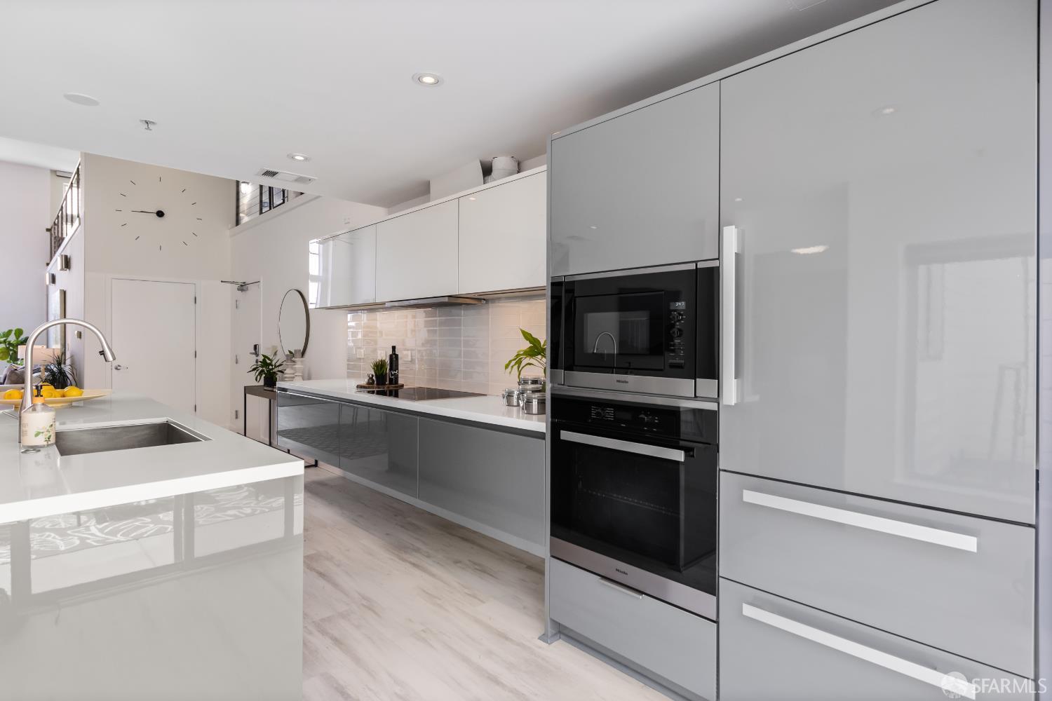 229 8th Street, Unit 3 San Francisco, CA 94103 - Photo 26 of 61 a kitchen with stainless steel appliances white cabinets and a stove top oven