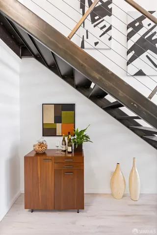 a bedroom with a bed and painting on the wall