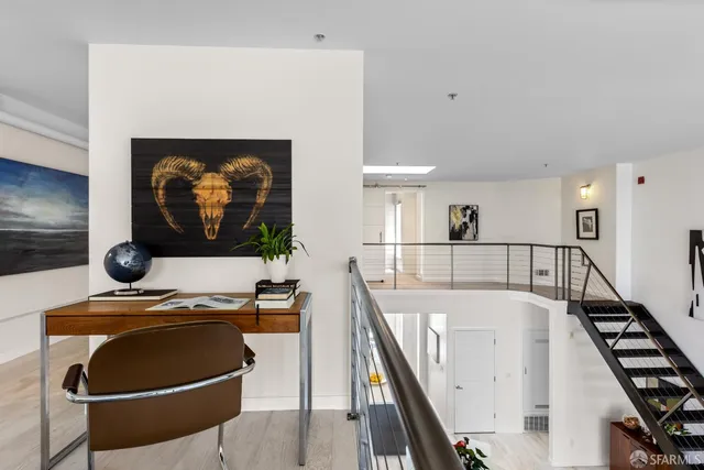 a view of a livingroom with furniture and a black and white kitchen